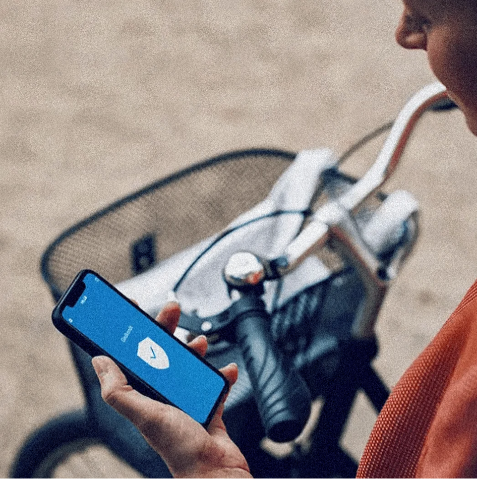 Person next to a bicycle holding a smartphone showing a digital identity verification screen
